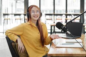 Female podcaster making audio podcast from her home studio photo