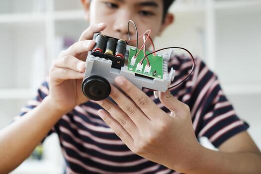 Asian teenager doing robot project in science classroom. technology of robotics programing and STEM education concept. photo