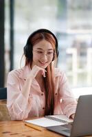 Young collage student using computer and mobile device studying online. photo