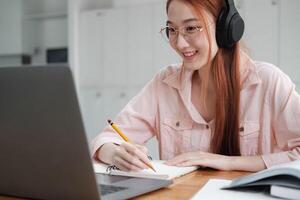 Young collage student using computer and mobile device studying online. photo