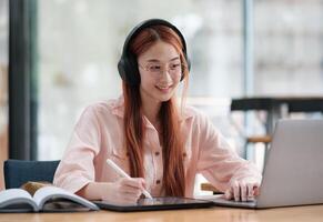 Young collage student using computer and mobile device studying online. photo
