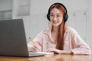 Young collage student using computer and mobile device studying online. photo
