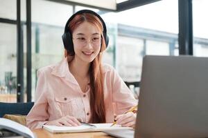 Young collage student using computer and mobile device studying online. photo
