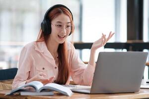 Young collage student using computer and mobile device studying online. photo