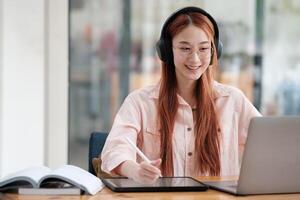 Young collage student using computer and mobile device studying online. photo