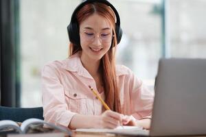 Young collage student using computer and mobile device studying online. photo