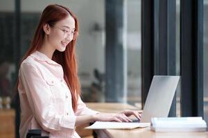 Young collage student using computer and mobile device studying online. photo
