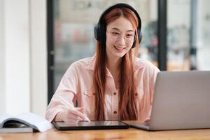 Young collage student using computer and mobile device studying online. photo