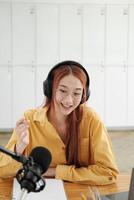 Female podcaster making audio podcast from her home studio photo