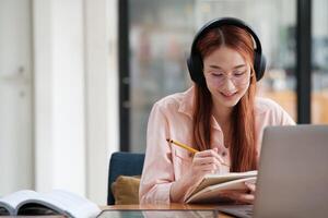 Young collage student using computer and mobile device studying online. photo
