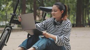 effrayant et détendu Jeune asiatique femme dans décontractée confortable vêtements équitation une vélo sur le bicyclette voie dans le parc. loisir et exercice concept video