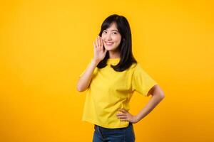 Portrait of a Young Asian Woman with Shout Hands Gesture Isolated on Yellow Studio Background photo