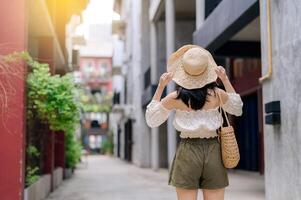 Happy youth asian woman with camera travels street city trip on leisure weekend. Young hipster female tourist sightseeing summer urban Bangkok destination. Asia summer tourism concept. photo