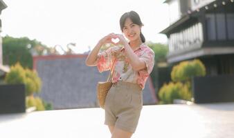 Portrait beautiful young asian woman on summer holiday vacation trip in Thailand. Young hipster female tourist sightseeing summer urban Bangkok destination. Asia summer tourism concept. photo