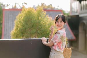 Portrait beautiful young asian woman on summer holiday vacation trip in Thailand. Young hipster female tourist sightseeing summer urban Bangkok destination. Asia summer tourism concept. photo