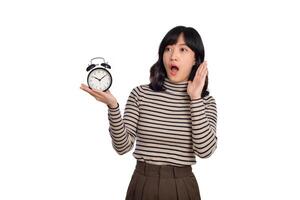 retrato de emocionado joven asiático mujer con suéter camisa participación alarma reloj aislado en blanco antecedentes foto