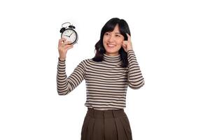 retrato de pensando joven asiático mujer con suéter camisa participación alarma reloj aislado en blanco antecedentes foto