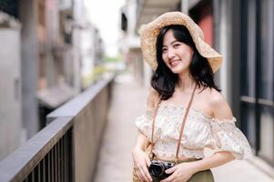 Happy youth asian woman with camera travels street city trip on leisure weekend. Young hipster female tourist sightseeing summer urban Bangkok destination. Asia summer tourism concept. photo