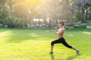 Embrace healthy outdoor lifestyle with image of fit Asian 30s woman wearing pink sportswear stretches muscles in public park before refreshing run, embodying the wellness concept and joy of fitness. photo