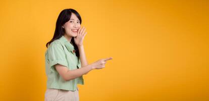 capturar compromiso y emoción con asiático joven mujer usa pastel verde camisa en naranja camisa espectáculo contento sonrisa mientras colocación mano terminado boca y señalando con un dedo a gratis Copiar espacio. foto