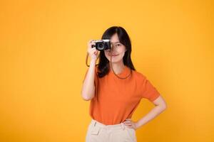 portrait cheerful young 30s asian woman happy smile with posing a camera isolated on yellow studio background. photo