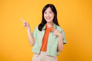 joven asiático mujer en su 30s vistiendo un verde camisa en un naranja camisa, señalando dedos a gratis Copiar espacio. explorar el concepto de descuento compras promoción con llamativo imagen. foto
