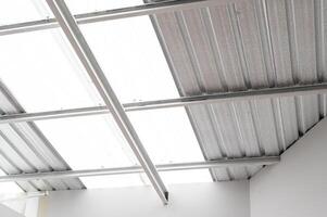 industrial grade metal roof insulation. heat resistant sheet foil provides thermal protection and energy efficiency. corrugated design and silver texture add modern and abstract touch to construction. photo