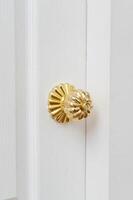 gold door knob handle. reflective surface and modern design add touch of luxury to entrance door. Crafted with metal and wood, this round knob shines with style and security. photo