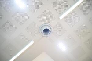 Ceiling mounted cassette type air conditioner and modern lamp light on white ceiling. Duct air conditioner for home, hall or office. photo