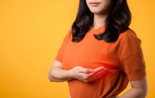 Take charge of breast health on World Health Day, woman checking for breast cancer signs on yellow background. photo