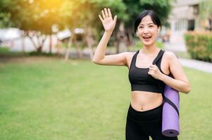 Yoga girl. Wellness and exercise concept illustrated by a young Asian woman doing yoga outdoors at sunset. Rubber mat workout in a natural setting. photo