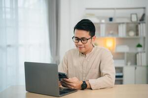 Business man smiling using smartphone on table, man using mobile phone to search or social media or shopping online or stock or crypto currency. Smart phone conversation conferrence. photo