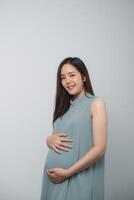 Pregnant woman holding on her belly making hand heart shape isolated on white background. Family mother mom pregnant concept. photo