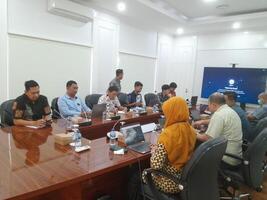 A group photo of people meeting in an office meeting room.