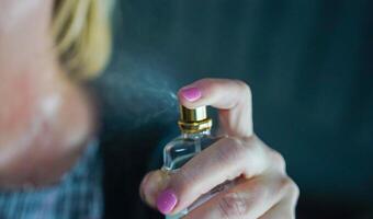 mujer pulverización perfume. mujer participación botella de perfume. foto