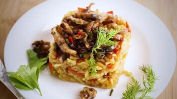 Diet pilaf with mushrooms and vegetables in a plate . video