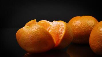 ripe tangerines with peel on black background video