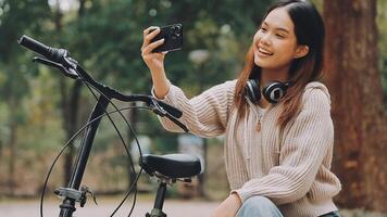 Bicycle, woman and phone in city feeling excited and happy about message while outdoor in summer with trendy look. Eco friendly transportation for carbon footprint female on a bike using 5g network video