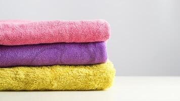 a pile of clean, folded and colored towels on a white background photo