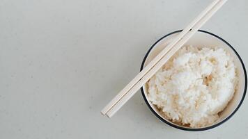 blanco arroz en un blanco cuenco con palillos foto