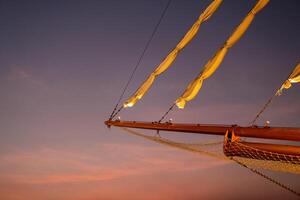 el propina de el barco tiene un lienzo. crepúsculo cielo antecedentes foto