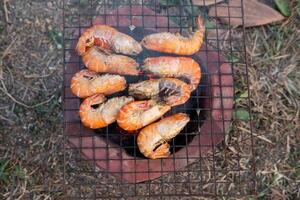 Grilled river prawns on a charcoal grill. photo