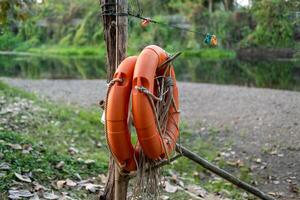 An orange lifebuoy hangs on a pole to prepare for the safety of people playing in the water. photo