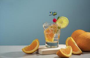 Cocktail in glass glass filled with ice and orange slice garnished with lemon slice, cherry and butterfly pin on a wooden board with pieces of oranges photo