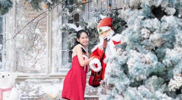 Portrait of teenage girl in a red dress relaxed and smiling in a snowy yard. photo