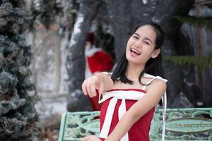 Portrait of teenage girl in a red dress relaxed and smiling in a snowy yard. photo