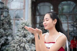 Portrait of teenage girl in a red dress relaxed and smiling in a snowy yard. photo