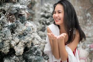 retrato de Adolescente niña en un rojo vestir relajado y sonriente en un Nevado patio trasero. foto