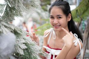 retrato de Adolescente niña en un rojo vestir relajado y sonriente en un Nevado patio trasero. foto