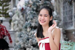 Portrait of teenage girl in a red dress relaxed and smiling in a snowy yard. photo